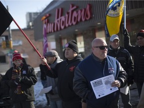 Protesters take part in a Labour Council-supported rally outside the Tim Hortons on University Avenue at Bruce Avenue downtown, Friday, Jan. 19, 2018.