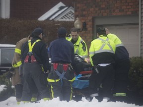 Paramedics and firefighters carry a woman to a stretcher after she slipped on ice outside her home on St. Louis Avenue on Jan. 10, 2018.