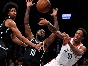 Toronto Raptors' DeMar DeRozan passes the ball around Brooklyn Nets' Quincy Acy and Jarrett Allen during the first half of an NBA basketball game on Jan. 8, 2018