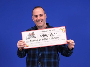 Raymond De Ridder, 33, of Chatham, holds up his $514,314 prize cheque from playing the OLG sports-betting game POOLS in December 2017.