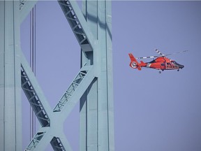 A U.S. Coast Guard helicopter searches the Detroit River near the Ambassador Bridge in this 2018 file photo.