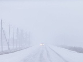 TECUMSEH, ONT:. DEC 24, 2017 -- A lone vehicle travel south on Arner Townline as heavy snow blankets the area, Sunday, Dec. 24, 2017.   (DAX MELMER/Windsor Star)     2017decemberpom