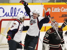 Peterborough Petes' goalie Dylan Wells looks away as Windsor Spitfires' Cole Purboo, left, and Curtis Douglas celebrate a goal during first period OHL action on Thursday at the Memorial Centre in Peterborough. CLIFFORD SKARSTEDT/PETERBOROUGH EXAMINER/POSTMEDIA NETWORK