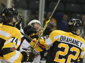 New Kingston Frontenacs defenceman Sean Day roughs up Windsor Spitfires Luke Boka with some help from his new teammate Jakob Brahaney during the first period of Ontario Hockey League action at the Rogers K-Rock Centre in Kingston on Friday.
Steph Crosier/Kingston Whig-Standard/Postmedia Network