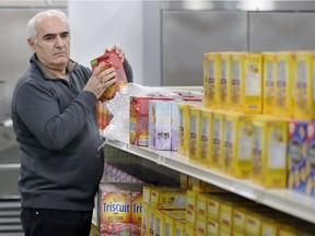 Volunteer Johnson Athori stocks shelves at the at Unemployed Help Centre's food bank on Feb. 2, 2018.