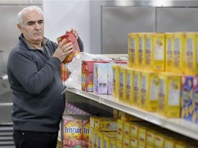 A volunteer stocks shelves at the Unemployed Help Centre's food bank on Feb. 2, 2018.