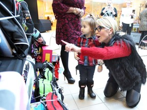 Stephanie Zekelman, right, points out a toy-filled backpack for cancer patient Zoe Dudzianiec, 2, during an event at Windsor Regional Hospital's Met campus on Feb. 12, 2018, which saw Transition To Betterness and the Stephanie and Barry Zekelman Foundation highlight a program that provides each child of the pediatric oncology and chronic illness unit with a backpack filled with fun, educational toys and items.