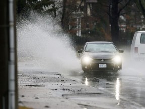 Motorists navigate through numerous puddles on Riverside Drive on Feb. 21, 2018.