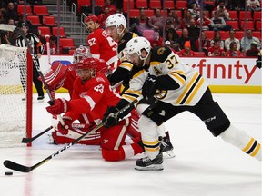 Patrice Bergeron #37 of the Boston Bruins battles for the puck with Trevor Daley #83 of the Detroit Red Wings during the third period  at Little Caesars Arena on February 6, 2018 in Detroit, Michigan. Boston won the game 3-2.