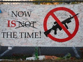 A sign hangs on a fence one at Marjory Stoneman Douglas High School in Parkland, Fl. on Feb. 27, 2018. The school was the site of a mass shooting on Feb. 14, 2018, where 17 people were killed and another 15 injured.