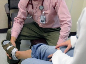 In this September 2008 file photo, a physician discusses an ankle injury with a patient in Lawrence, Kan. Arthritis isn't always from the wear-and-tear of getting older. Too often, younger people get it after suffering knee or ankle injuries.