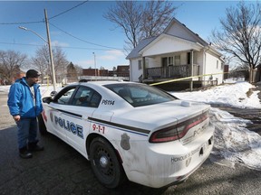 A Windsor police cruiser is seen at a home in the 3200 block of Bloomfield Road in Windsor's west end on Feb. 18. Todd Peretti, who lives nearby and says he knew the dead man, speaks to an officer in front of the home.