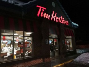 A customer walks out of a Tim Hortons restaurant in Newcastle, Ont. on Sunday Feb. 11, 2018. Restaurant price hikes led food inflation in January with analysts saying the 3.7 per cent bump likely comes from Ontario eateries attempting to offset the province's recent minimum wage increase.THE CANADIAN PRESS/Doug Ives