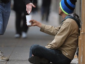 A panhandler in downtown Windsor gets a helping handout in this Oct. 13, 2017, file photo. Caesars Windsor employees donated backpacks Tuesday to the homeless.