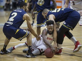 Windsor's Omar Strong hits the floor in a loose ball battle with St. John's Edge's Coron Williams, left, and Grandy Glaze in NBLC action at the WFCU Centre on Feb. 2018.  The Express lost 112-108.