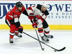 Ottawa Senators Zack Smith (15) battles for the puck with New Jersey Devils Taylor Hall (9) during second period NHL action in Ottawa on  Feb. 6, 2018.