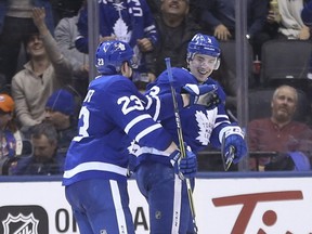 Toronto Maple Leafs Travis Dermott congratulates teammate Justin Holl after he scored his first goal during the third period in Toronto on Febr. 1, 2018.