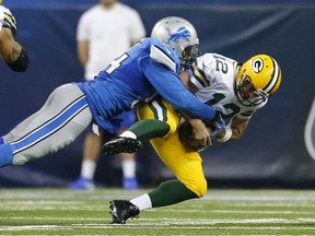 In this Dec. 3, 2015, file photo, Green Bay Packers quarterback Aaron Rodgers (12) is sacked by Detroit Lions defensive end Ezekiel Ansah (94) during an NFL football game in Detroit.