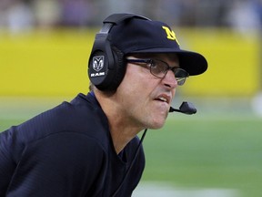 FILE - In this Sept. 2, 2017, file photo, Michigan head coach Jim Harbaugh watches play against Florida late in the second half of an NCAA college football game, in Arlington, Texas. Michigan plays at Indiana on Oct. 14, 2017.