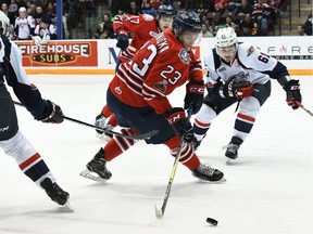 Oshawa Generals' forward and Tecumseh native Jack Studnicka (23) tries to control the puck as Windsor Spitfires' Cole Purboo (26) and Luke Boka (61) close in during Sunday's game at Tribute Communities Centre.