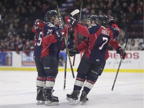 The Windsor Spitfires, including Zach Shankar, left, and Tyler Angle, celebrate after a goal earlier this season.