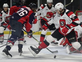 ole Purboo, left, of the Windsor Spitfires, and Merrick Rippon, of the Ottawa 67s, scramble for the puck during Thursday's game at the WFCU Centre.