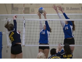 St. Anne Saints' Jenna Pellerito, centre, and Ashley Ditchfield attempt to block St. Joseph's Amelia Oliverio during the WECSSAA senior girls AAA volleyball final on Wednesday.