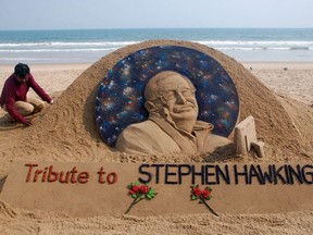 Sand artist Sudarsan Patnaik gives final touches on March 14, 2018, to a sculpture at a beach in India in honour of British physicist and award-winning author Stephen Hawking, who was not only a genius but made geeks seem cool.