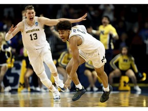 Jordan Poole #2 and Moritz Wagner #13 of the Michigan Wolverines celebrate Poole's 3-point buzzer beater for a 64-63 win over the Houston Cougars during the second round of the 2018 NCAA Men's Basketball Tournament at INTRUST Bank Arena on March 17, 2018 in Wichita, Kansas.