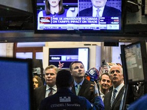 Traders work on the floor at the New York Stock Exchange. President Trump's announcement for new tariffs caused volatility in the markets on Friday.