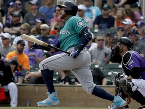 Seattle Mariners' Nelson Cruz watches his RBI-single against the Colorado Rockies during the first inning of a spring training baseball game in Scottsdale, Ariz., Tuesday, March 13, 2018.