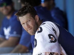 Los Angeles Dodgers starting pitcher Clayton Kershaw sits in the dugout before a spring training baseball game against the Chicago White Sox, Friday, March 2, 2018, in Glendale, Ariz.
