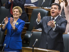 Ontario Finance Minister Charles Sousa and Premier Kathleen Wynne clap after Sousa delivers the provincial budget on March 28, 2018.