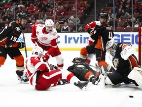Players are tangled up as Anaheim Ducks goaltender John Gibson makes a save during the first period of an NHL hockey game against the Detroit Red Wings Friday, March 16, 2018, in Anaheim, Calif.