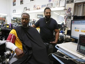 In this March 11, 2018, photo, barber Eric Muhammad, owner of A New You Barbershop, takes the blood pressure of customer Marc M. Sims in Inglewood, Calif. Black male customers at dozens of Los Angeles area barbershops reduced one of their biggest health risks through a novel project that paired barbers and pharmacists to test and treat customers.