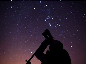 Dan Taylor, a member of the Windsor Centre of the Royal Astronomical Society of Canada, looks at the night sky through binoculars while at Point Pelee National Park on Feb. 9, 2013.  Once a month, on a Saturday closest to the new moon, the park remains open until midnight to celebrate it's 2006 designation as a Dark Sky Preserve.