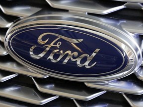 FILE- This Feb. 15, 2018, file photo shows a Ford logo on the grill of a 2018 Ford Explorer on display at the Pittsburgh Auto Show.