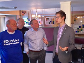 MPP Sam Oosterhoff (PC—Niagara West-Glanbrook), youngest representative ever elected to a Canadian legislature, chats with Chris Lewis, centre, and other Tory supporters during an informal meeting in Kingsville on March 12, 2018.