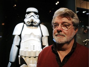 FILE - In this Oct. 22, 2005 file photo, filmmaker George Lucas poses in front of a Stormtrooper exhibit at the Museum of Science in Boston, prior to the opening of "Star Wars: Where Science Meets Imagination." Lucas is visiting a galaxy on the edge of downtown Los Angeles to break ground on his $1.5 billion Lucas Museum of Narrative Art. The "Star Wars" creator and his wife will be joined Wednesday morning, March 14, 2018, by several city and county officials to ceremoniously begin work on turning a section of Exposition Park into the new museum.