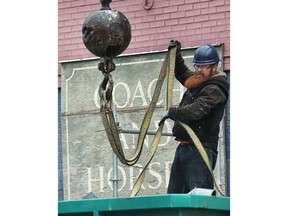 Old duct work is removed from the roof of the former Fish Market and Loop building in downtown Windsor on March 29, 2018 as the renovation project continues. Worker Jake Laramie unhooks straps from a crane during the process.