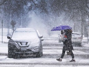 A pedestrian trudges through wet snowfall on Kildare Road in Windsor on March 1, 2018.