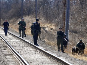 K-9 units and other police officers search Millpond Park in Mount Pleasant, Mich., Friday, March 2, 2018, during a manhunt for a man suspected of killing two people in a residence hall on Central Michigan University's campus.