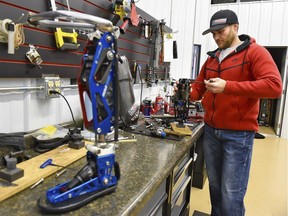 FILE - In this Dec. 22, 2017, file photo, Mike Schultz, who is preparing to compete in the 2018 Winter Paralympics in South Korea and is owner of BioDapt, works on a performance prosthetic for an athlete in his shop in St. Cloud, Minn.