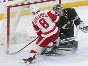 Detroit Red Wings' Justin Abdelkader, left, goes wide of the post on a scoring attempt against Minnesota Wild goalie Devan Dubnyk in the second period of an NHL hockey game, Sunday, March 4, 2018, in St. Paul, Minn.