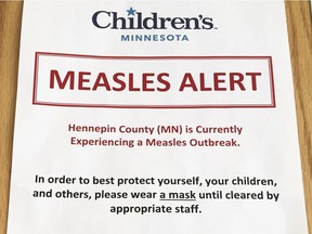 In this May 2, 2017, file photo, a sign at a Minneapolis hospital alerts patients to a measles outbreak in the area. There have been reports of measles infection among air travellers, most recently last week at Detroit Metro Airport.