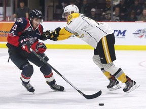 Luke Kutkevicius, left, of the Windsor Spitfires and Colton Kammerer of the Sarnia Sting battle for the puck during their game on Tuesday, March 27, 2018, at the WFCU Centre in Windsor, ON.