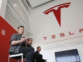 FILE - In this July 26, 2016, file photo, Elon Musk, CEO of Tesla Motors Inc., left, discusses the company's new Gigafactory in Sparks, Nev.