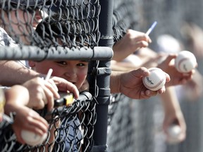 Fans wait to get autographs before a spring training baseball game between the New York Yankees and Detroit Tigers Feb. 23, 2018, in Tampa, Fla.