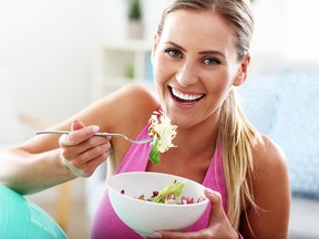 Fit woman eating healthy salad after workout