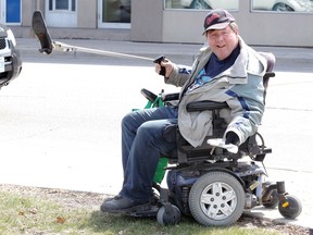 From a seat on his motorized wheelchair, Don Hamel picks up litter including an old, women's shoe along Goyeau Street in Windsor Monday April 2, 2018.